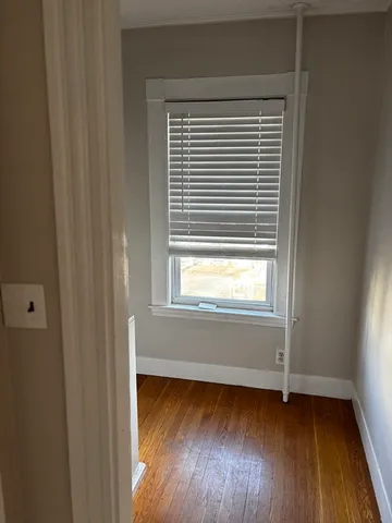 a view of a room with wooden floor and a window