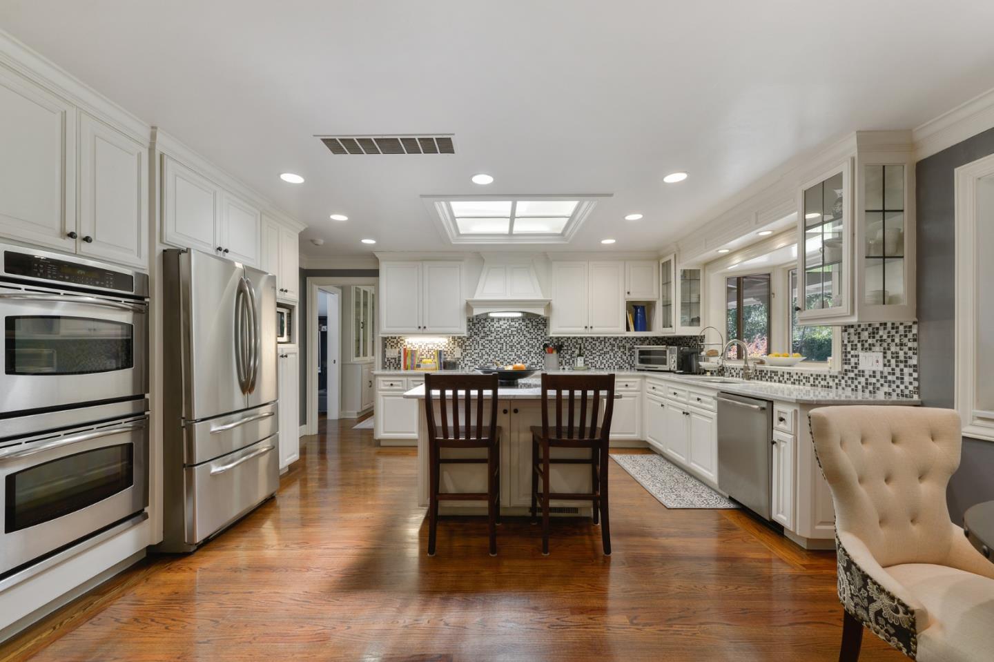 261 Atherton Avenue Atherton, CA 94027 - Photo 10 of 49 a kitchen with stainless steel appliances granite countertop a table chairs sink refrigerator and cabinets