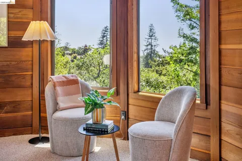 a living room with furniture and a painting on the wall