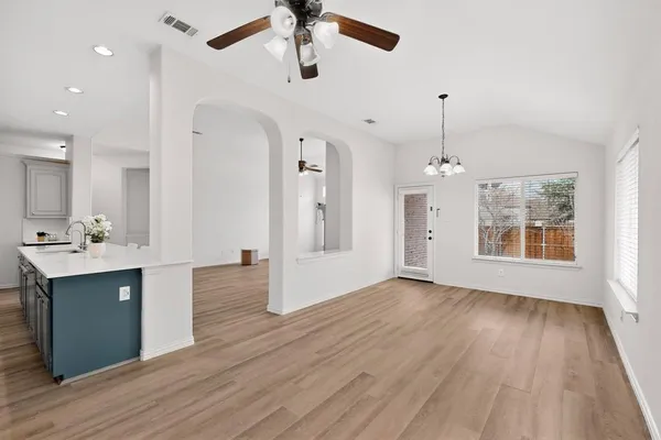 a view of a kitchen with a sink dishwasher a refrigerator and wooden floor