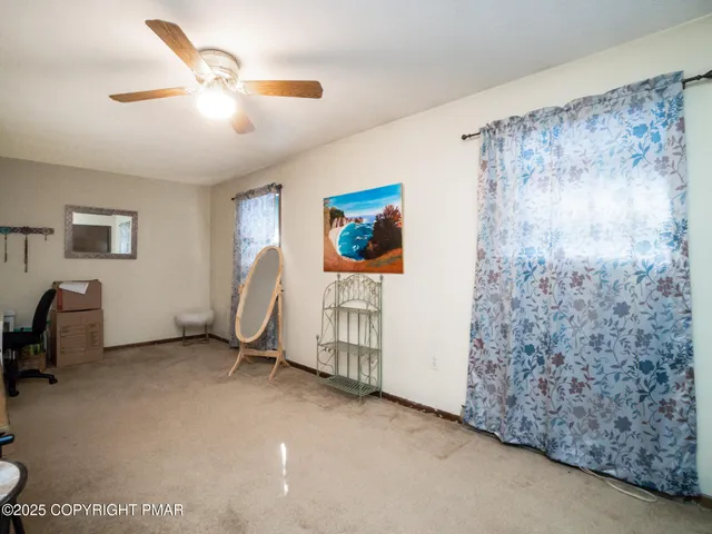 a view of a livingroom with workspace and a window