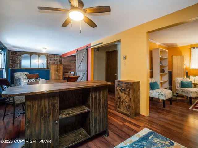 a kitchen with stainless steel appliances granite countertop a table chairs and a wooden floor