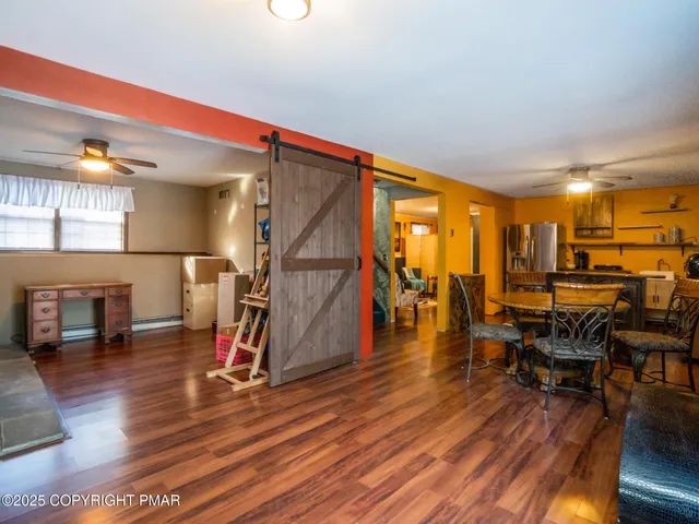 a view of a room with lots of furniture and wooden floor