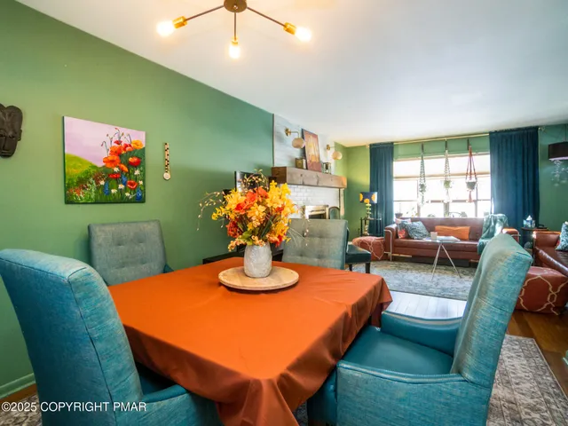 a view of a dining room with furniture a rug and wooden floor
