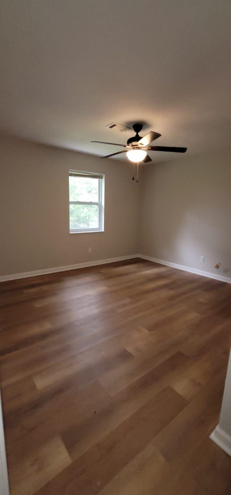 2888 Parrott Avenue Northwest, Unit A Atlanta, GA 30318 - Photo 15 of 21 an empty room with wooden floor chandelier fan and windows