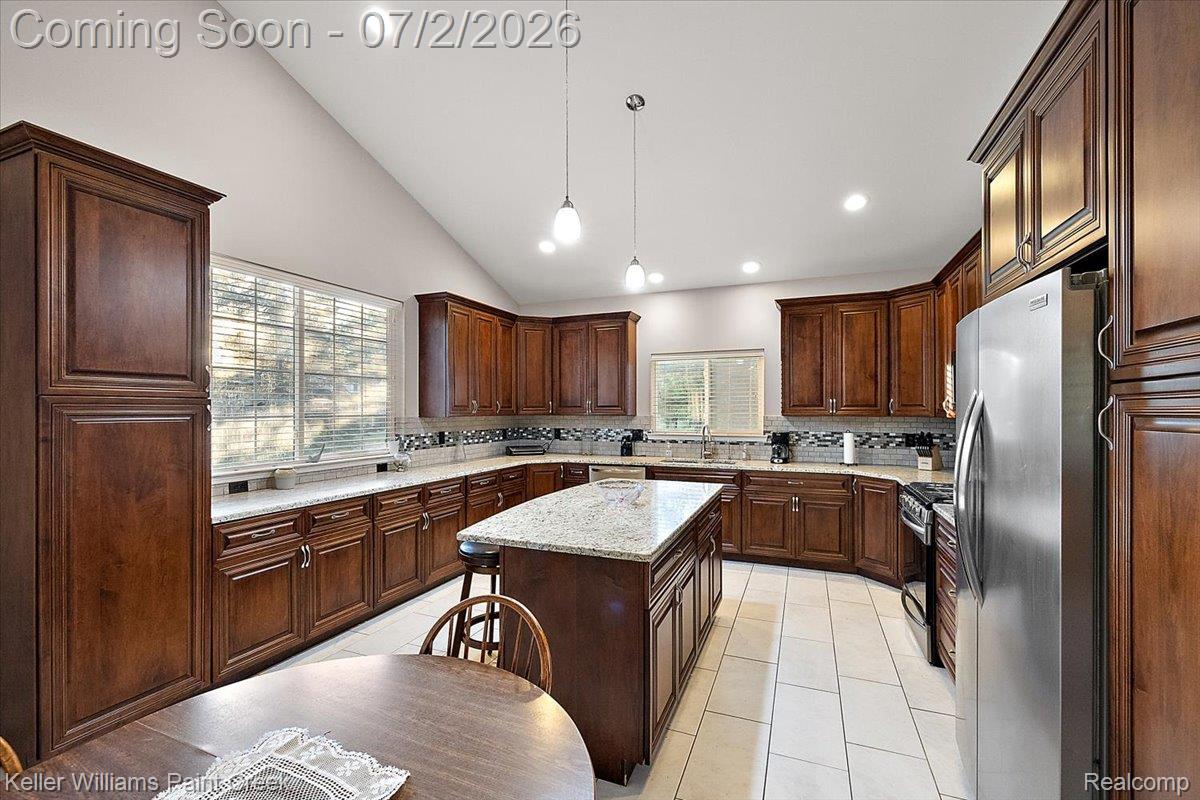 54230 Card Road Macomb, MI 48042 - Photo 37 of 73 Kitchen featuring vaulted ceilings, recessed lighting, wood cabinetry, stone countertops, and tile flooring