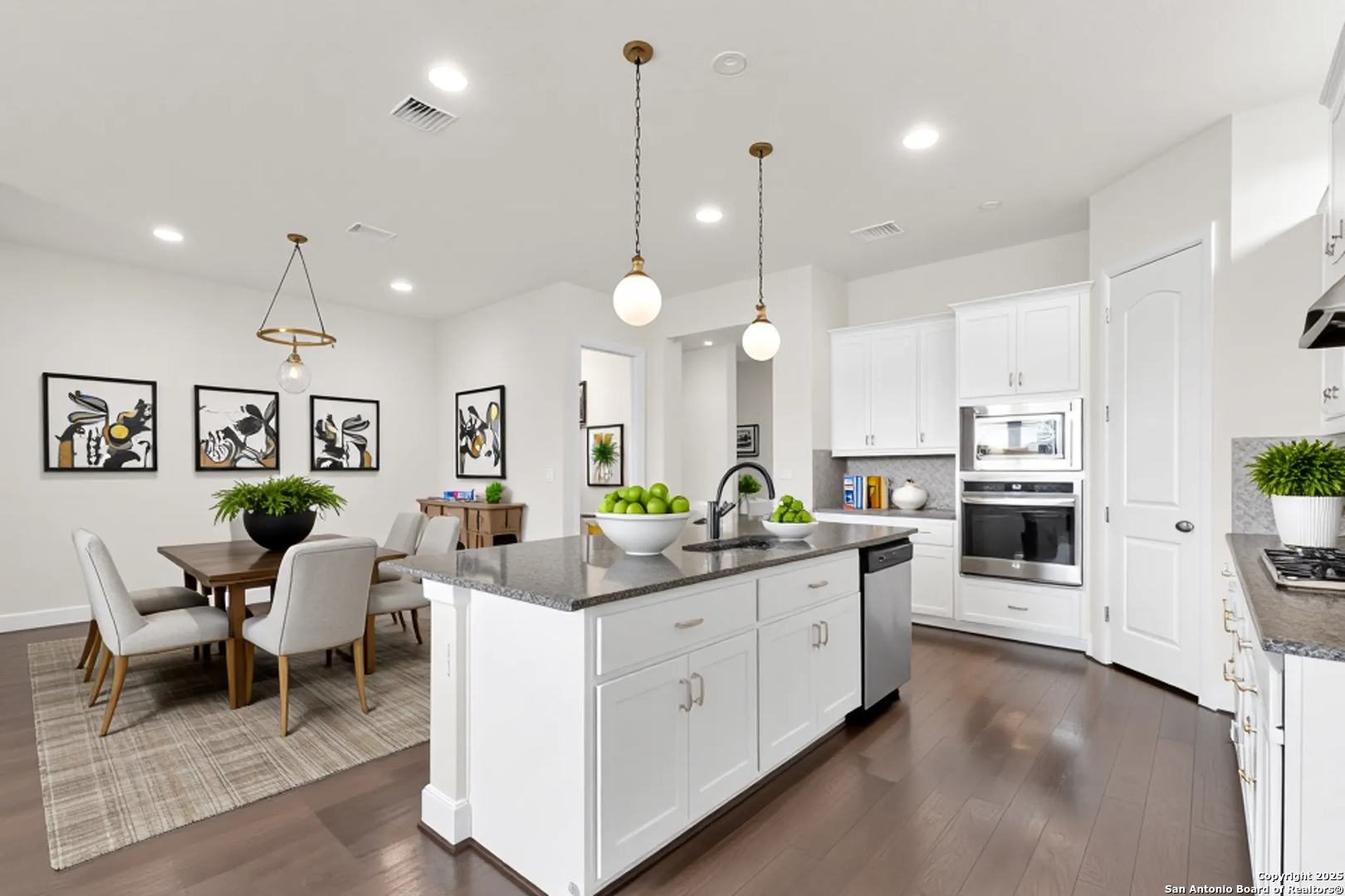 945 Foxbrook Way Cibolo, TX 78108 - Photo 2 of 20 a large white kitchen with lots of counter space dining table and stainless steel appliances