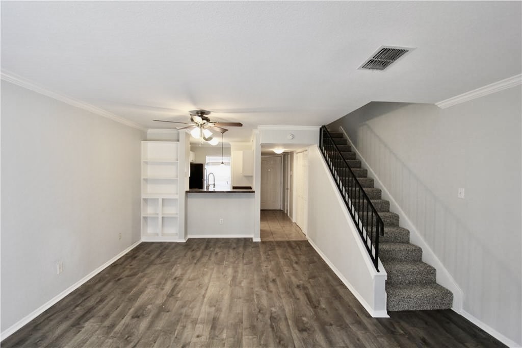 2018 West Rundberg Lane, Unit 14B Austin, TX 78758 - Photo 1 of 1 Living room with stairway, dark wood finished floors, a ceiling fan, ornamental molding, and baseboards