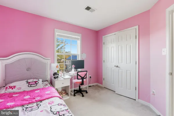 a bedroom with a bed a chair and a window