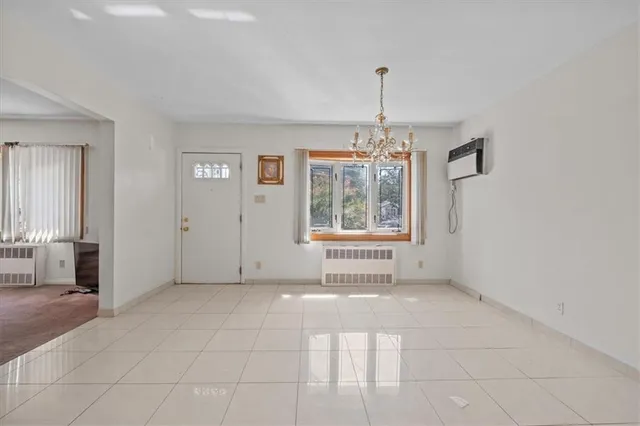 an empty room with windows and chandelier