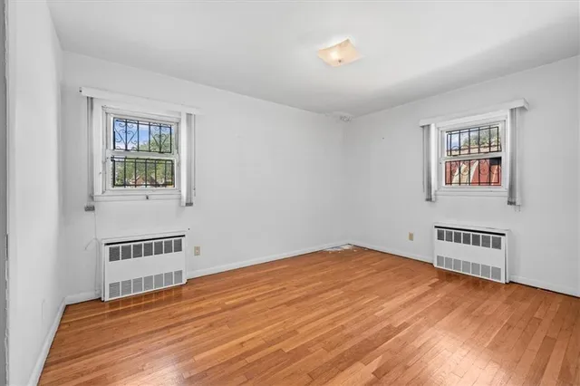 a view of a bedroom with wooden floor and a window