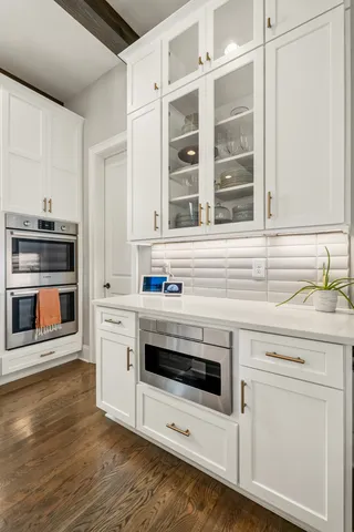 a kitchen with stainless steel appliances a cabinets and a table