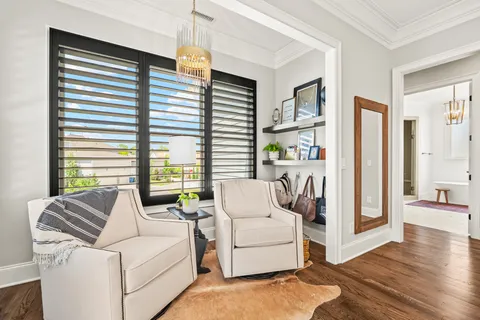 a living room with a table chairs and entryway