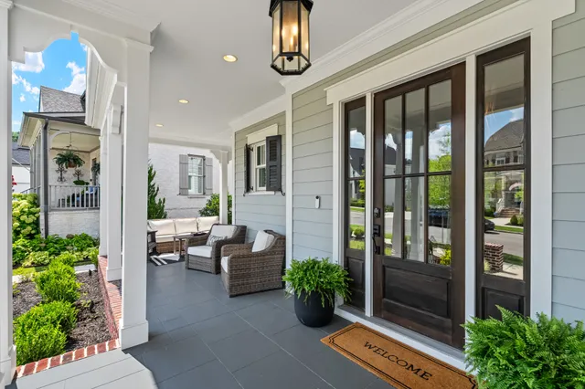 a view of a hallway to a livingroom with furniture wooden floor and a chandelier