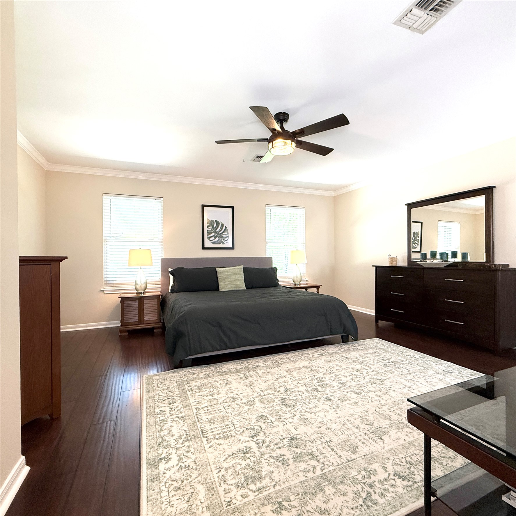 1902 Rowe Loop Pflugerville, TX 78660 - Photo 13 of 38 3rd master retreat Bedroom with ensuite bath featuring dark wood-style floors, ornamental molding, and ceiling fan