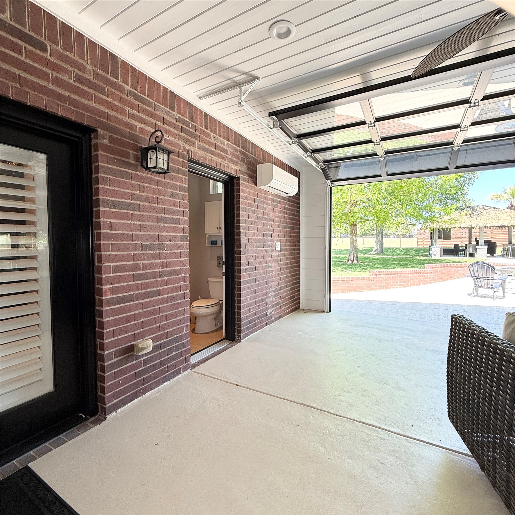 1902 Rowe Loop Pflugerville, TX 78660 - Photo 25 of 38 Outdoor living area featuring glass garage doors, mini split, fireplace, seating areas, and 1/2 bath