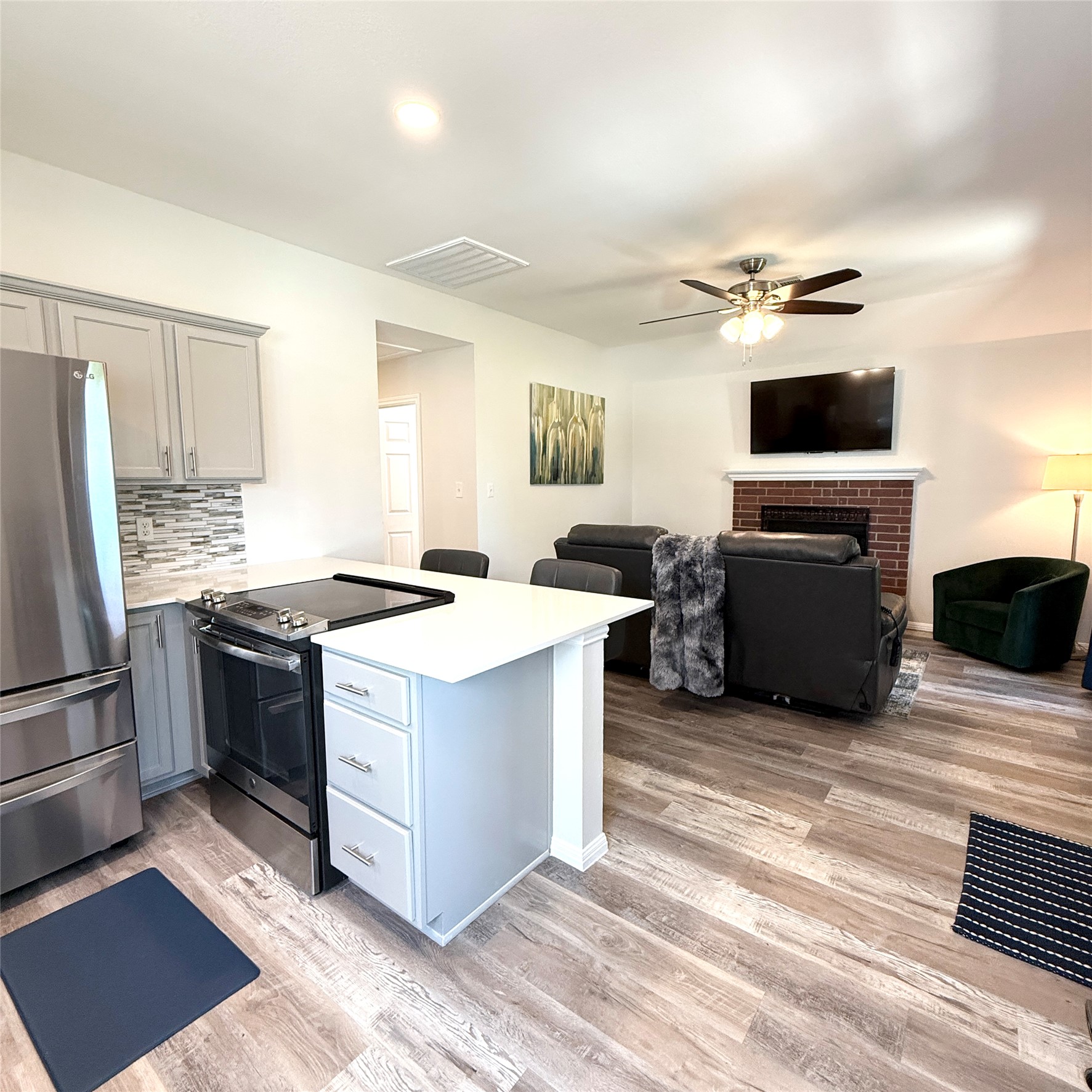 1902 Rowe Loop Pflugerville, TX 78660 - Photo 31 of 38 Guest House Kitchen featuring a peninsula, stainless steel appliances, gray cabinets, and light wood-style floors