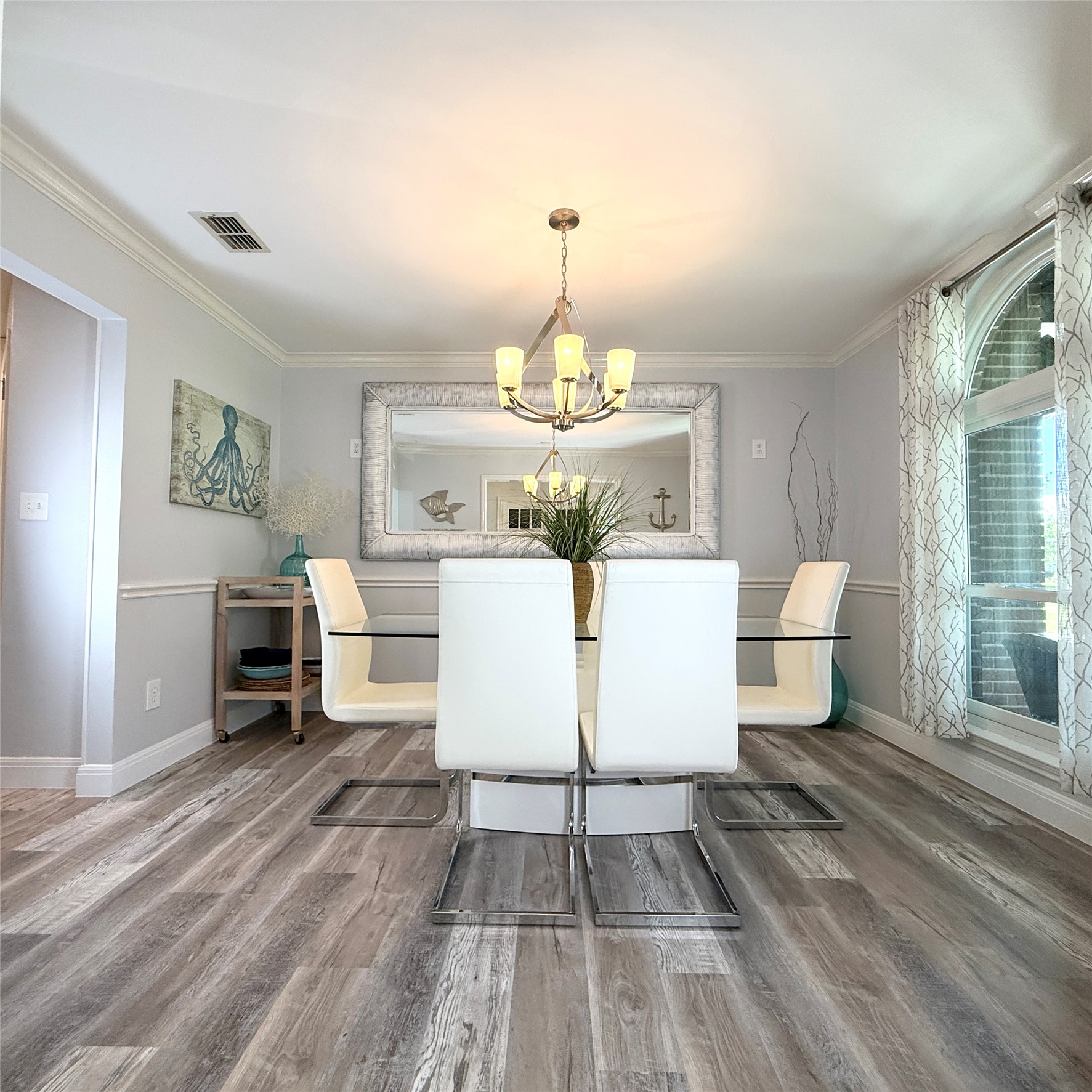1902 Rowe Loop Pflugerville, TX 78660 - Photo 9 of 38 Dining room with a chandelier, wood finished floors, and crown molding connected to kitchen