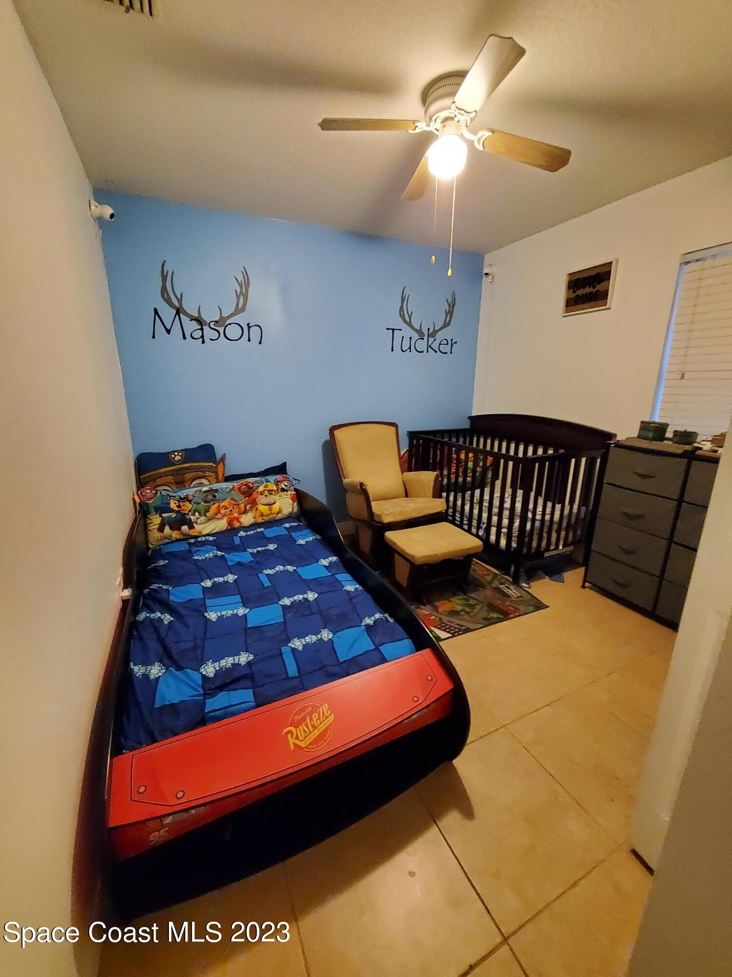 6845 Spring Street Cocoa, FL 32927 - Photo 31 of 45 a bedroom with a bed and a chandelier