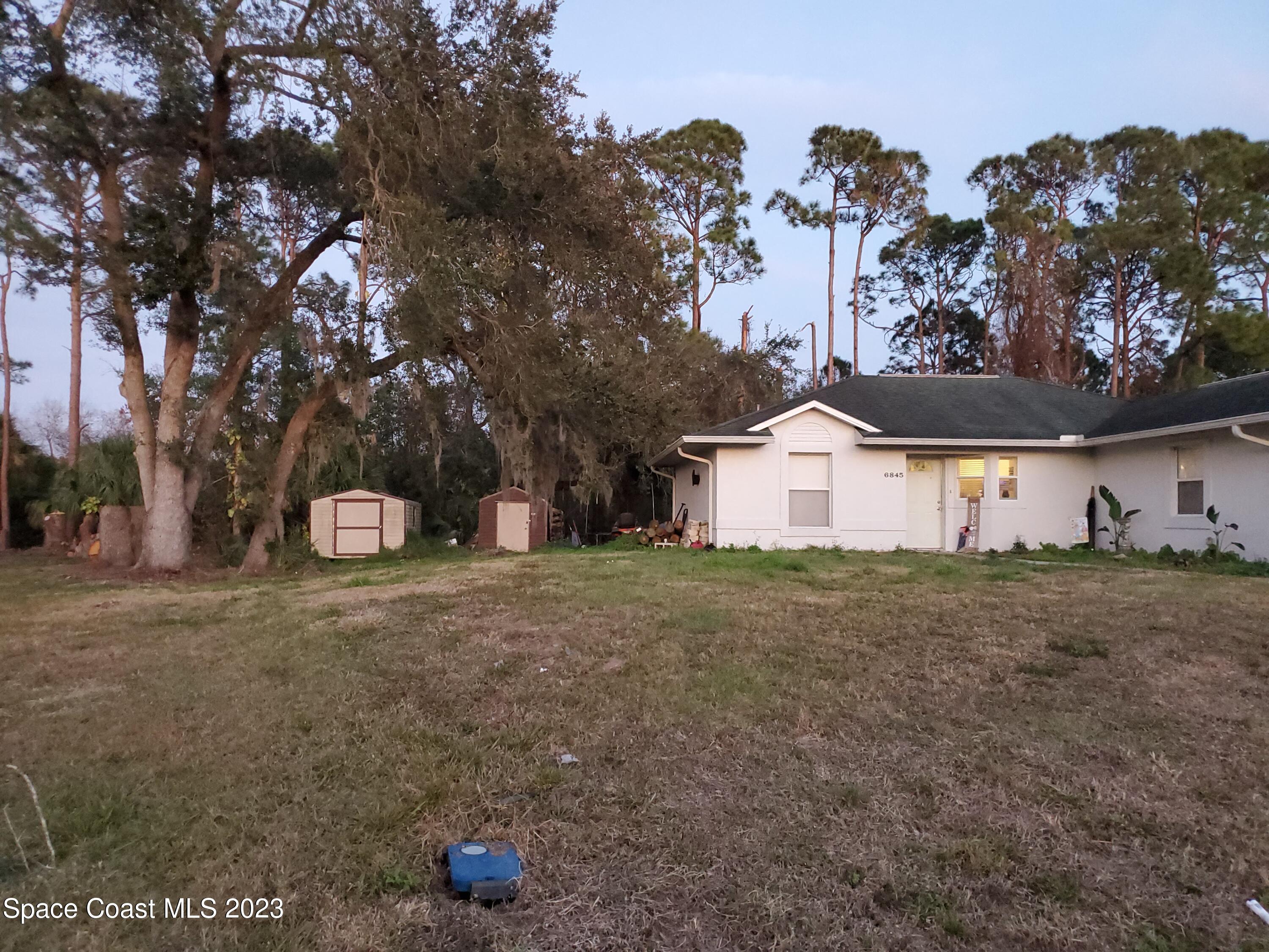 6845 Spring Street Cocoa, FL 32927 - Photo 43 of 45 a front view of a house with a yard and garage