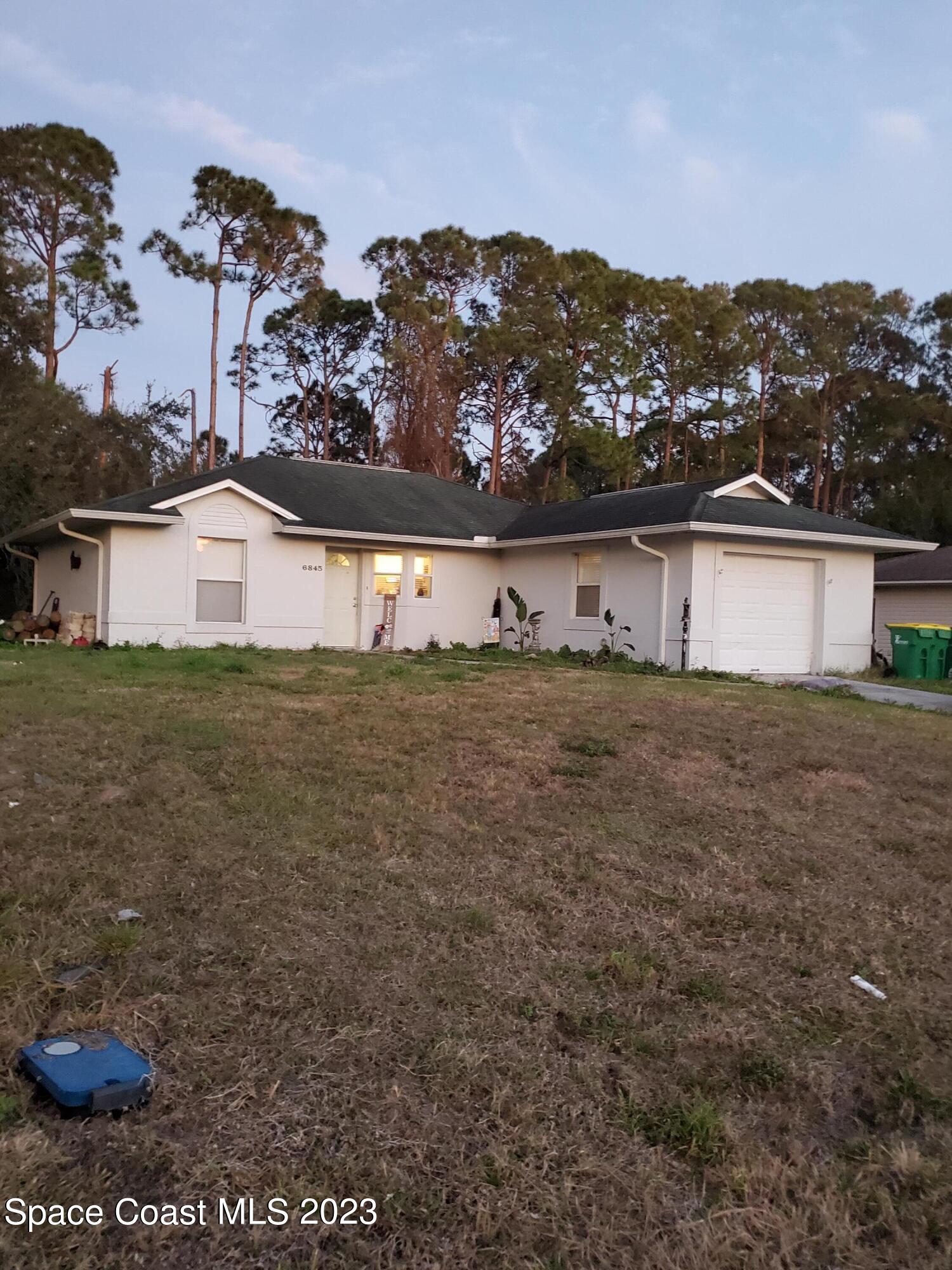 6845 Spring Street Cocoa, FL 32927 - Photo 44 of 45 a view of a house with a yard