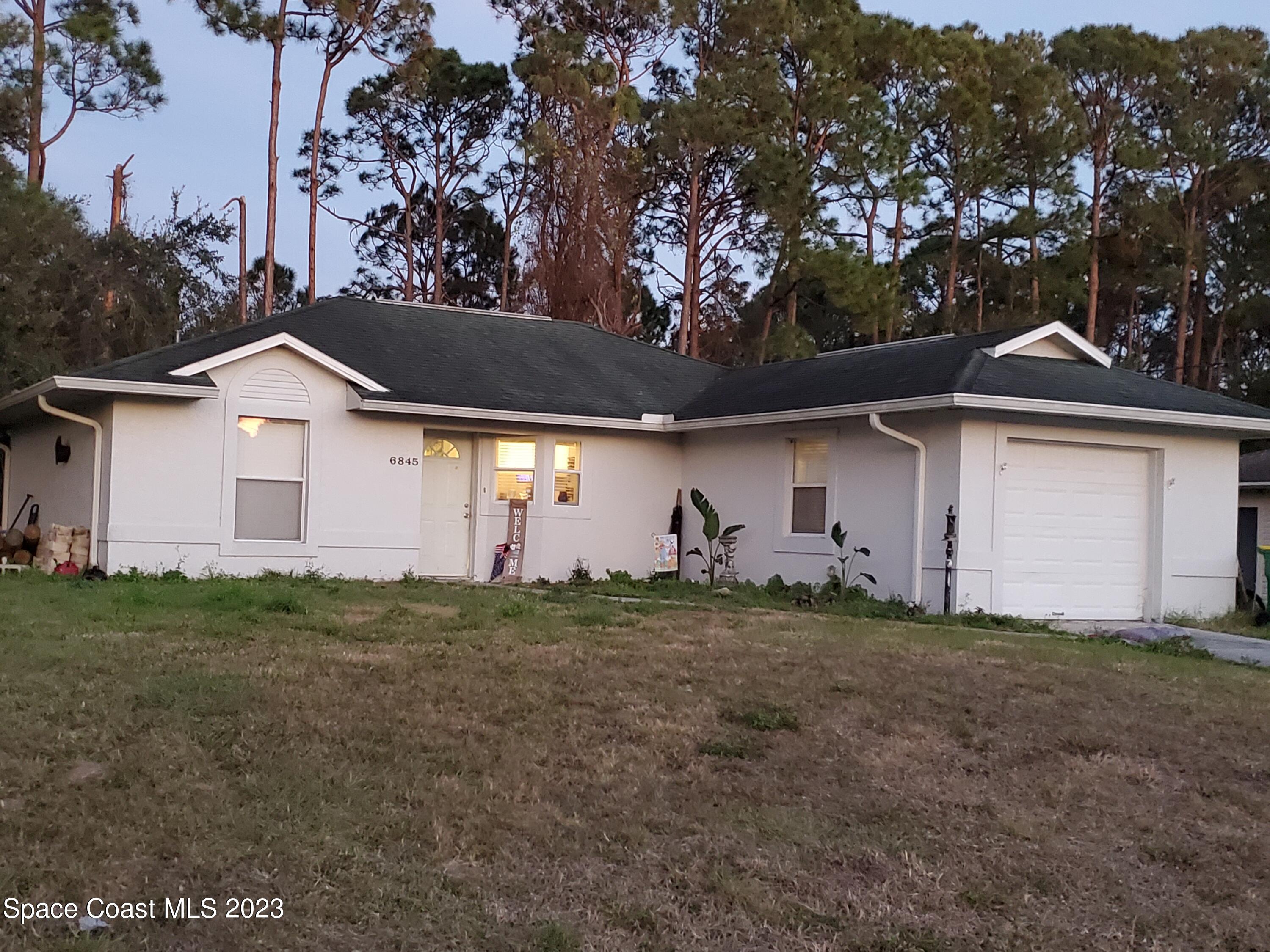 6845 Spring Street Cocoa, FL 32927 - Photo 10 of 45 a front view of a house with a yard
