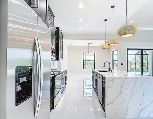 a kitchen with stainless steel appliances granite countertop a sink a stove and a refrigerator