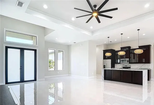 a kitchen with stainless steel appliances kitchen island granite countertop a refrigerator a sink and a stove