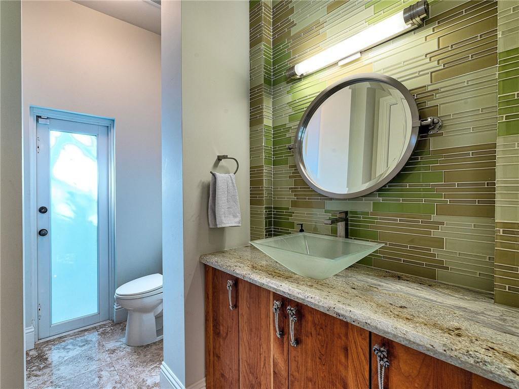 2920 Hunter Road Weston, FL 33331 - Photo 20 of 51 a bathroom with a granite countertop toilet a sink and a mirror