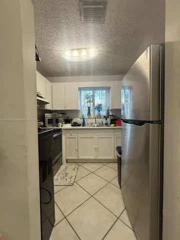 a kitchen with a refrigerator a sink and cabinets
