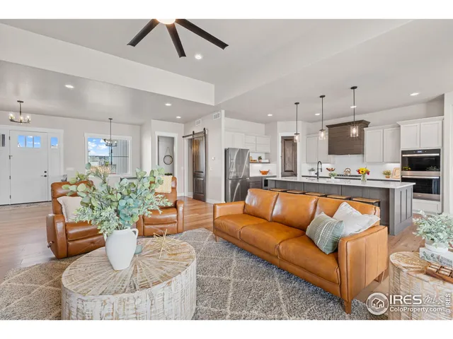 a living room with stainless steel appliances kitchen island granite countertop furniture and a couch