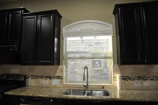 a kitchen with granite countertop a sink and a stove