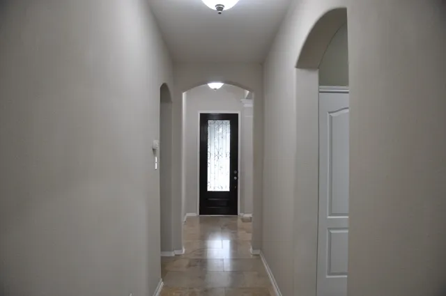 a view of a hallway with wooden staircase