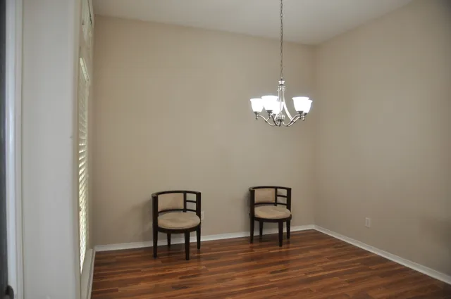 a view of a hallway with wooden floor and a chandelier
