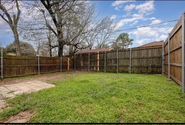 a view of a backyard with wooden fence