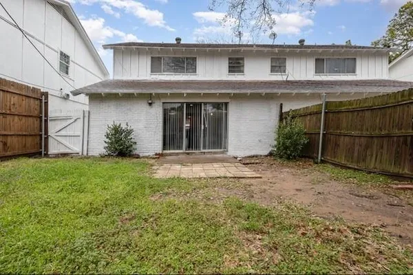 a view of a house with brick walls and a yard
