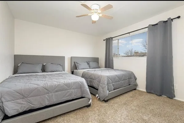 a bedroom with two beds and a chandelier