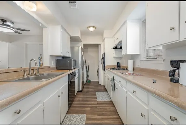 a kitchen with a sink stove cabinets and refrigerator