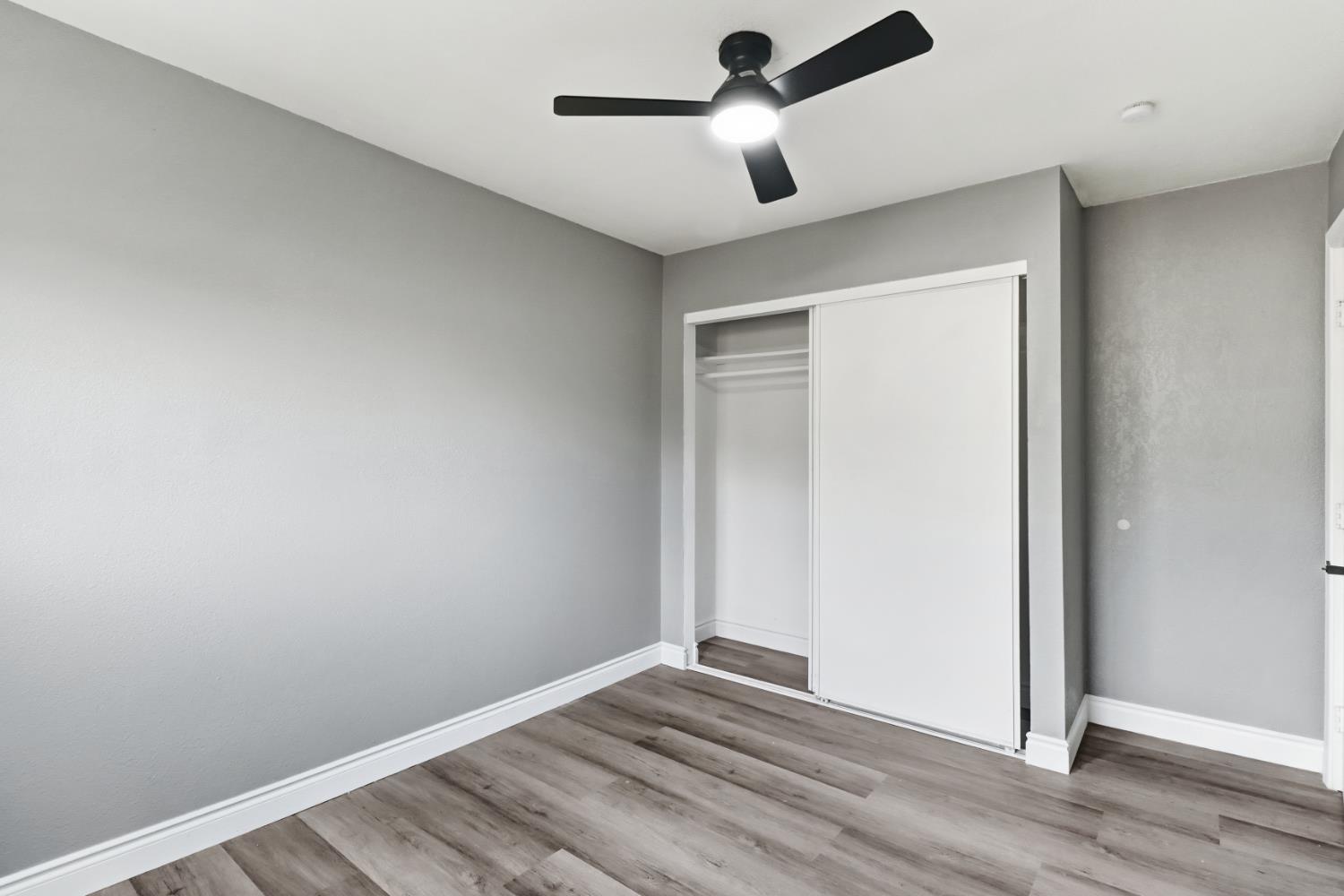 1099 Grand Avenue Olivehurst, CA 95961 - Photo 15 of 38 an empty room with wooden floor and ceiling fan
