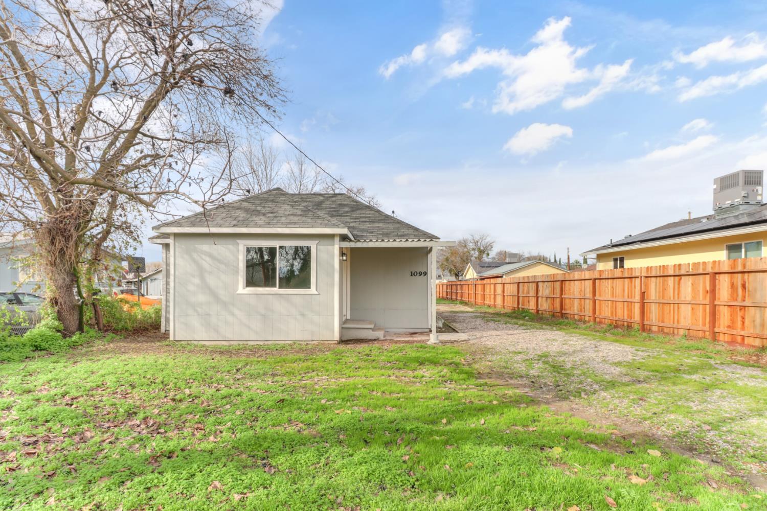 1099 Grand Avenue Olivehurst, CA 95961 - Photo 35 of 38 a backyard of a house with large trees and table and chairs