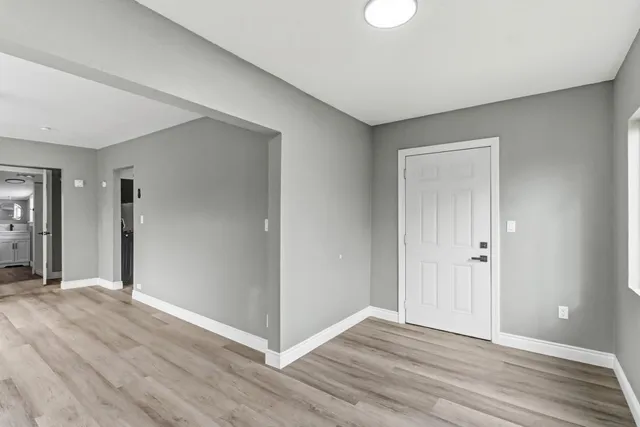 a view of an empty room with wooden floor