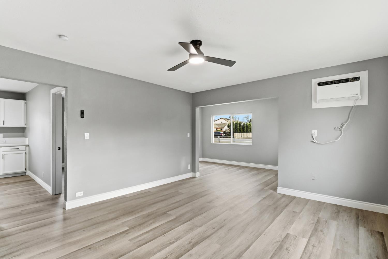 1099 Grand Avenue Olivehurst, CA 95961 - Photo 8 of 38 an empty room with wooden floor a ceiling fan and windows