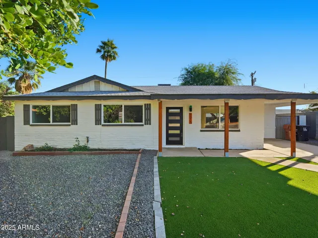a front view of a house with a yard and trees