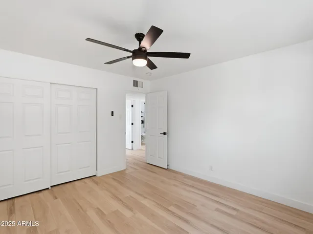 a view of a big room with wooden floor closet and windows