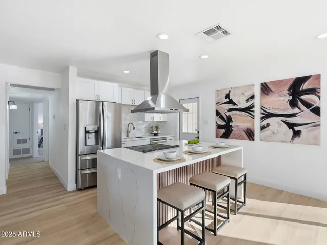 a kitchen with a table chairs and white cabinets