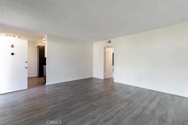 a kitchen with stainless steel appliances granite countertop a refrigerator a stove and a sink with wooden floor