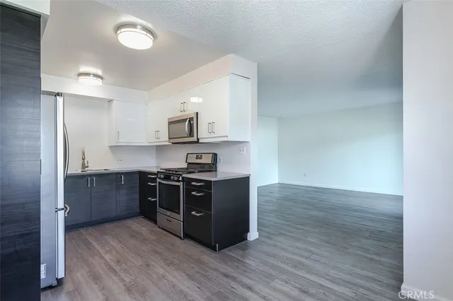 a kitchen with stainless steel appliances a stove a microwave and sink
