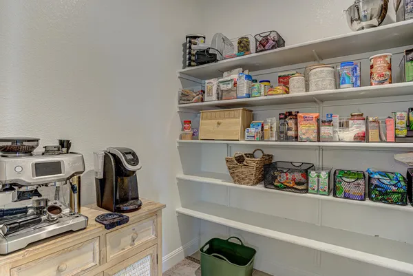 a bedroom with a large bed a couch and a chandelier