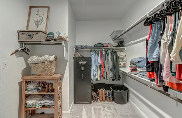 a view of walk in closet with clothes