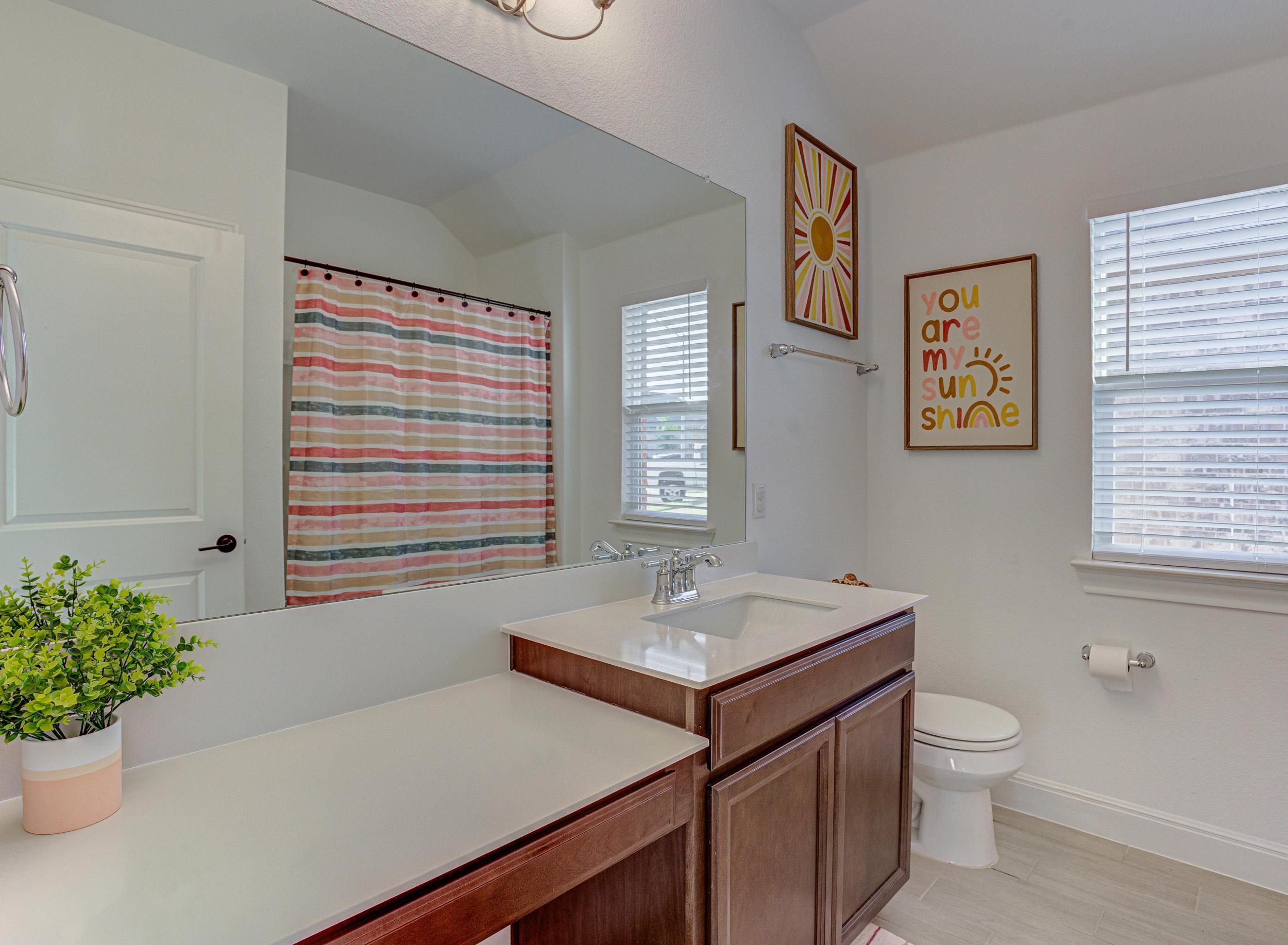 149 Slenderleaf Drive Marble Falls, TX 78654 - Photo 22 of 30 a bathroom with a sink a toilet and a large mirror